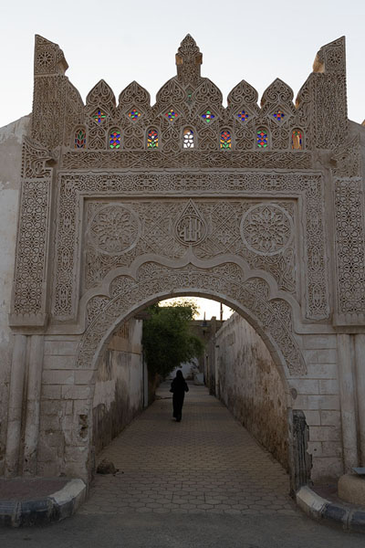 Afternoon sun shining through decorated gate with stained glass in Farasan | Casas viejas de Farasan | Arabia Saudita