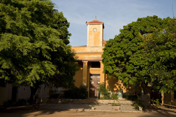 Picture of Ile de Gorée (Senegal): Small square with trees and St. Charles church in the late afternoon