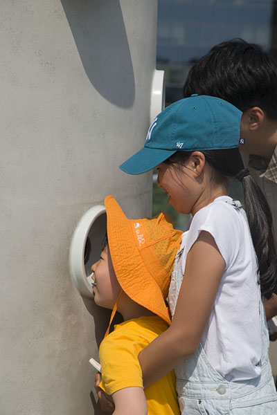 Kid looking through a peephole on the overpass | Seoullo 7017 | South Korea