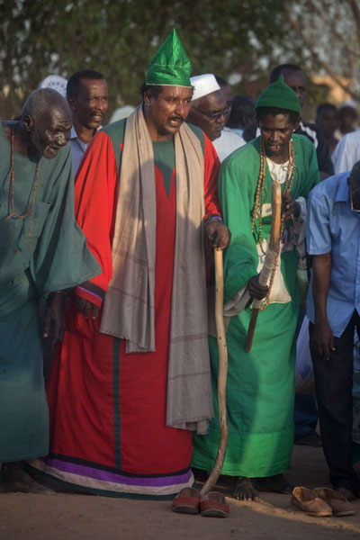 Dervish dressed in red and a green hat | Hamed El Nil dervisci | Sudan