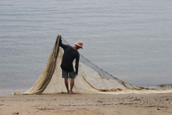 Picture of Fisherman arranging his nets on the beach near Ban PheThailand - Thailand