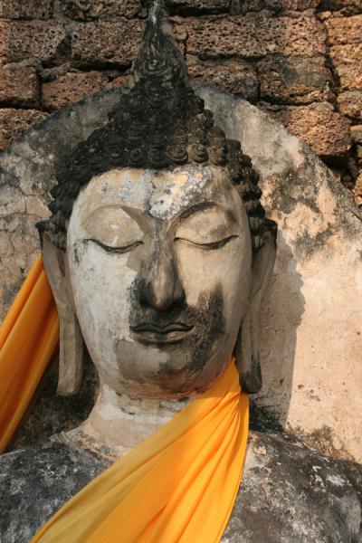 Detail of Buddha dressed up in orange shawl | Si Satchanalai | Thailande