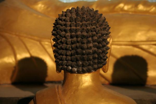 Foto van Golden Buddha flanked by praying figuresWat Tham Suwannakuha - Thailand
