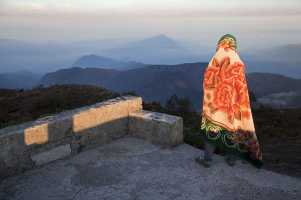 Shadow of Mount Ramelau, and guide protecting himself against the cold | Mont Ramelau | Timor Oriental