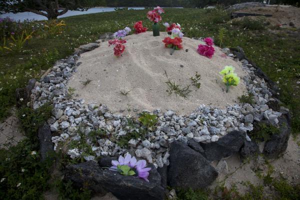 Foto van Coral stones with sand, sea shells and fake flowers form a grave on Vava'u islandTonga begraafplaatsen - Tonga