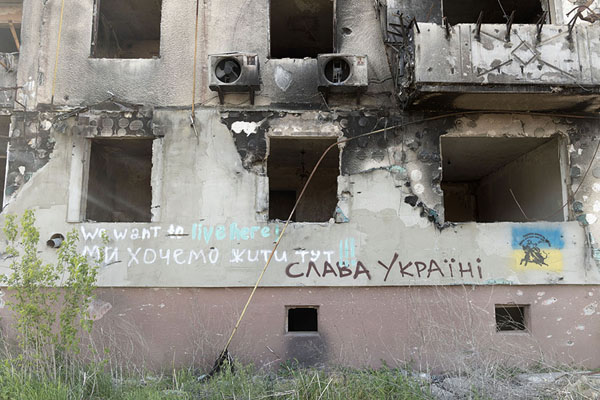 Foto van We want to live here, and Glory to Ukraine, painted on a destroyed building in BorodyankaBorodyanka - Oekraïne