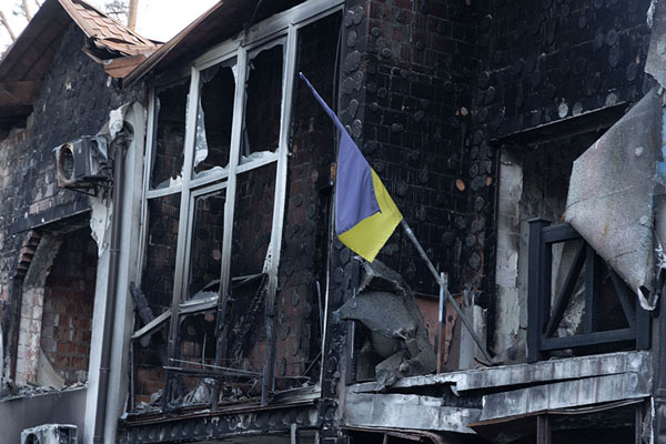 Foto van Ukrainian flag bringing colour into the burned out ruins of a house in Irpin - Oekraïne - Europa