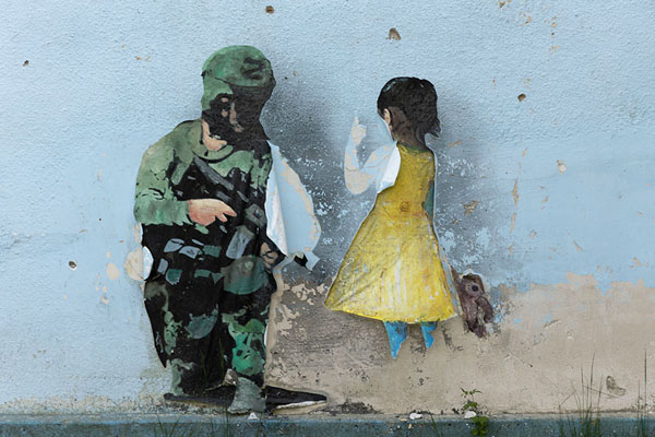 Picture of Soldier with girl: graffiti by TVBoy on a wall of the Culture House of Irpin