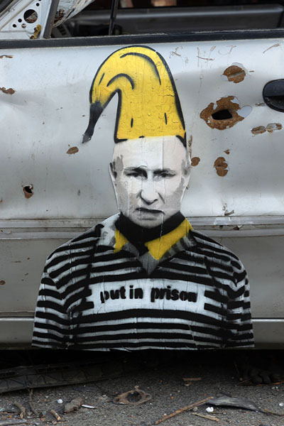 Foto van Putin in prison clothes painted on a car wreck near Irpin - Oekraïne - Europa