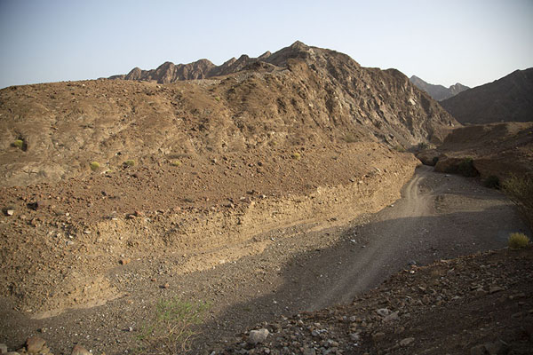 Foto van View of wadi with track in the west of Nahwa counter enclaveMadha Nahwa Enclave - Verenigde Arabische Emiraten
