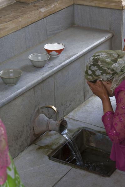 Woman applying the power of the holy water | Tumba del profeta Daniel | Uzbekistán