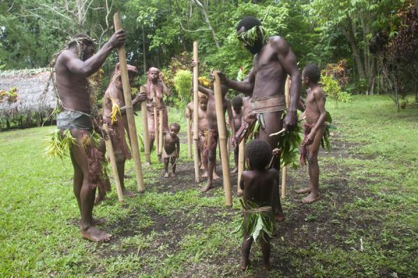 Picture of Making music by hitting the earth with wooden sticksMae - Vanuatu