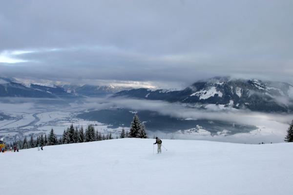 Skiing the slopes of St. Johann with a view of the cloudy valleys | St. Johann Skiing | Austria