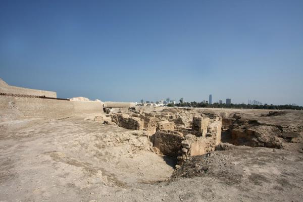 Ruins of ancient city with the skyline of Manama in the background, Bahrain Fort, Bahrain