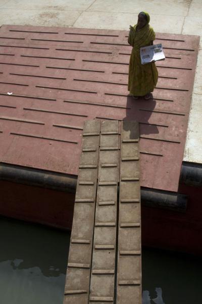 Woman selling newspapers at one of the boat stops of the Rocket, Bangladesh