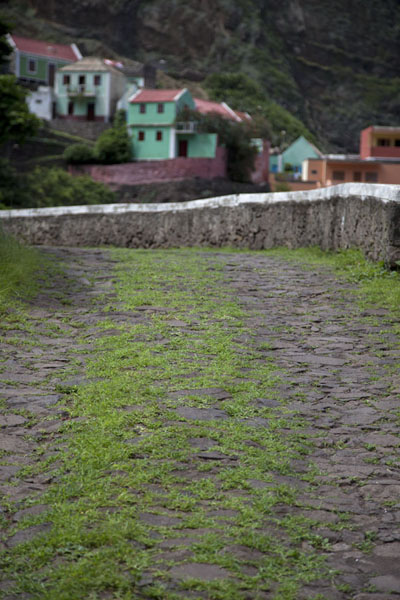 The stony road with grass and Fontainhas in the background, Cabo Verde