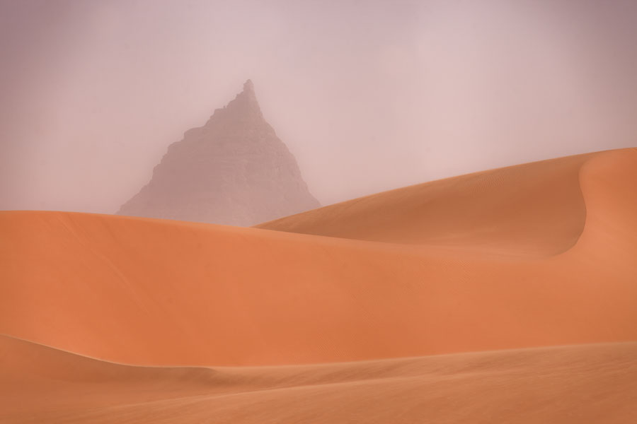 Curved sand dunes with mountain peak in the desert | Eyo demi | Ciad