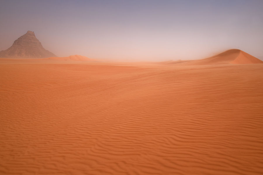 Sand dune with wind blowing over the top and mountain on the left | Eyo demi | Ciad