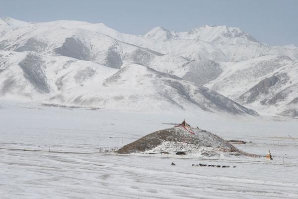 Snow covered mountains and hill with prayer flags seen from Batang sky burial site, China