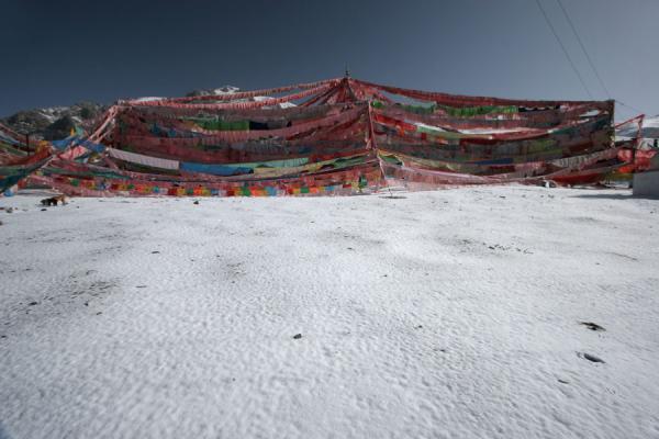 Prayer flags, snow and an intensely blue sky, China