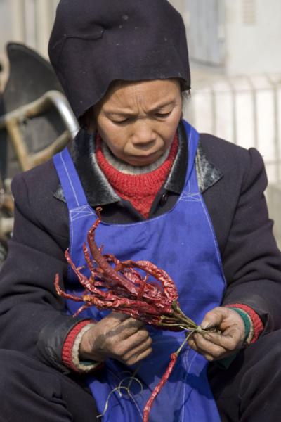 Market woman tying chillies together | MarchÃ© de Gedong | Chine