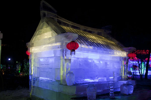 Transparent ice blocks in a traditional temple with orange lanterns, China