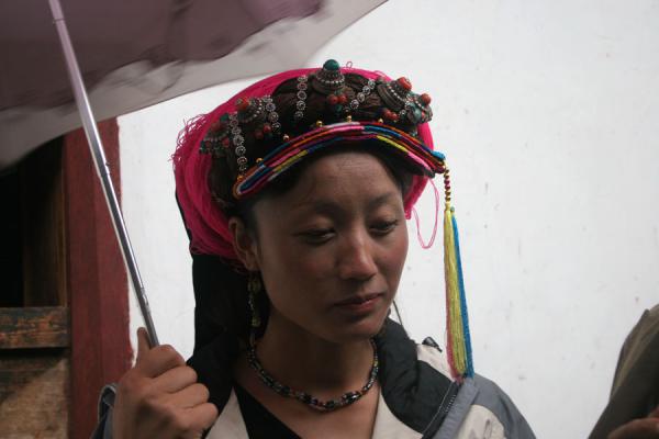 Young Khampa woman with traditional jewellery and umbrella, China