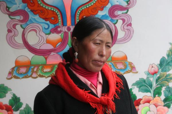 Lovely Khampa woman with richly decorated wall, China