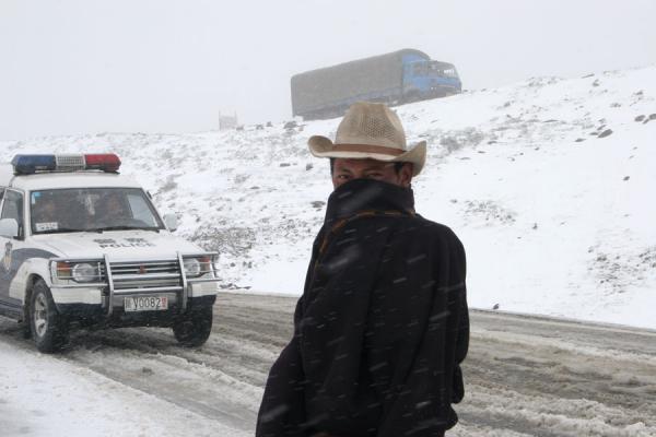 Tibetan walking up Zheduo pass in the snow, China