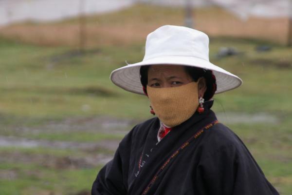 Tibetan woman with white hat and cap in the Kham countryside, China