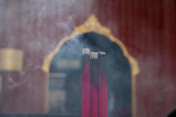 Incense burning at one of the many burners outside a temple, China