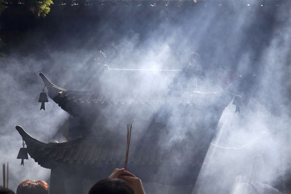 Sunlight filtering through smoke of burning incense | Putuoshan | China