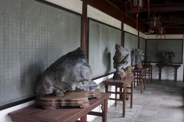 Confucian writings on the wall with curiously shaped stones and pieces of wood in front, Confucian Temple, China