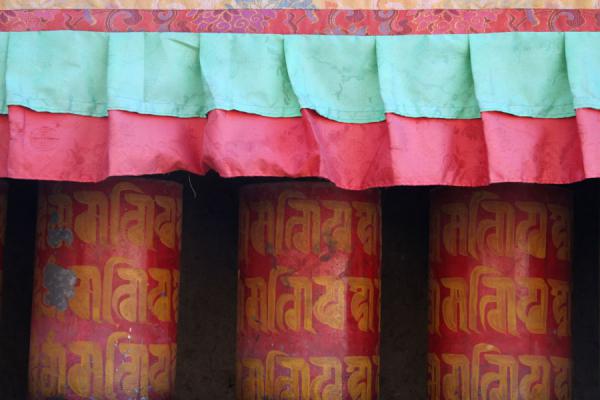 Red and yellow painted prayer wheels on Tashilhunpo kora, China