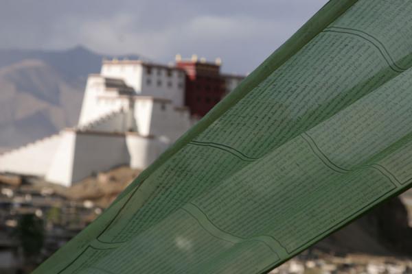 Prayer flag with the completely renewed fortress in the background, China