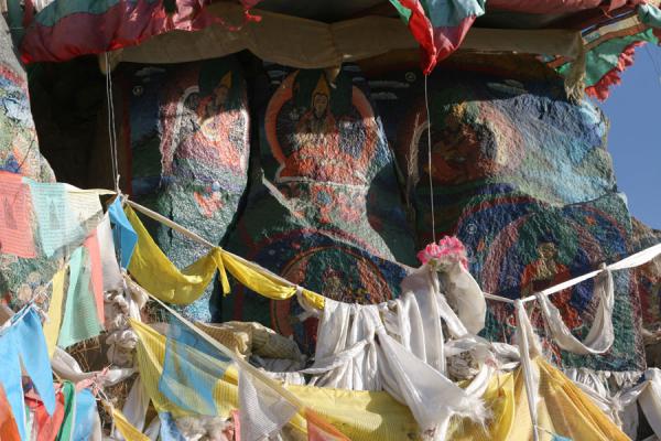 Prayer flags decorating colourful rockpaintings on Tashilhunpo kora, China