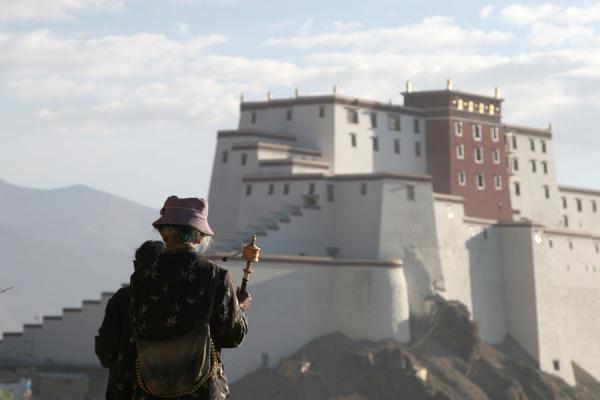 Pilgrims on Tashilhunpo kora with Shigatse fortress in the background, China