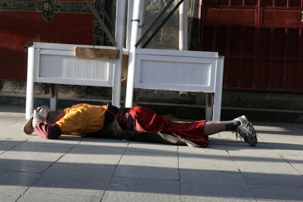 Tibetan pilgrim prostrating on the streets of Lhasa | Pellegrini tibetani | Cina