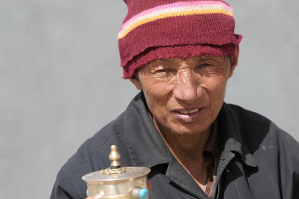 Tibetan pilgrim turning his prayer wheel in Dondrubling monastery | Pellegrini tibetani | Cina