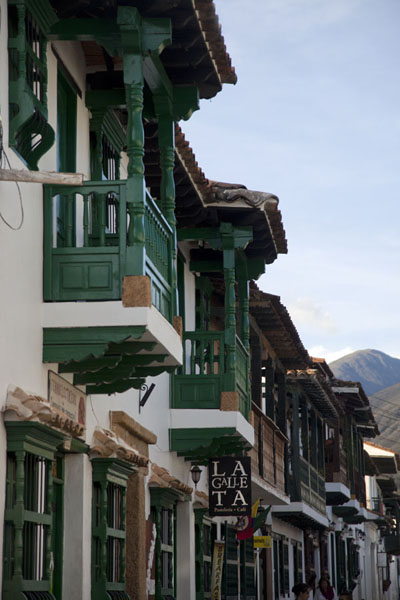 White houses with green balconies and window shutters in a street of Villa de Leyva, Colombia