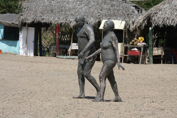 People covered in mud walking towards the lagoon to wash the mud off, Colombia