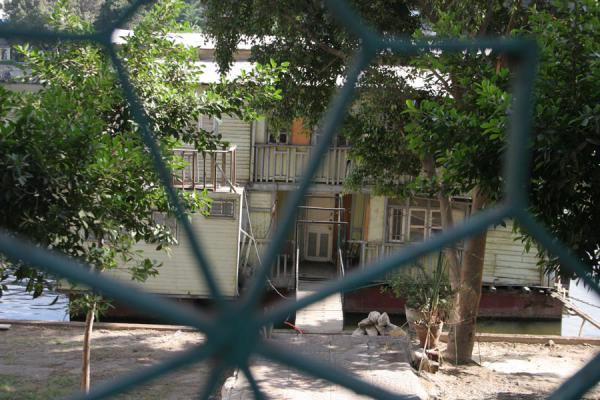 Houseboat on the river Nile seen through a fence, Egypt One of the houseboats seen through a fence, Egypt