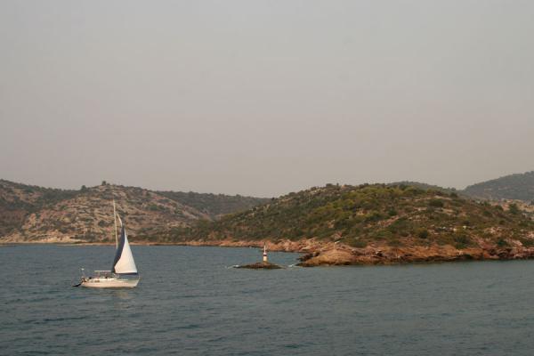 Sailboat approaching a cape on Poros island, Greece