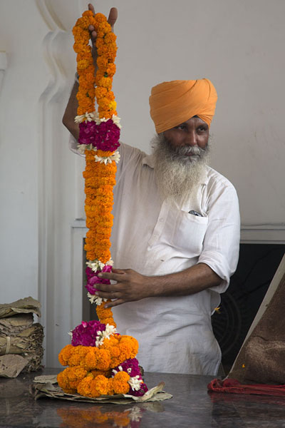 Sikh offering garlands at the entrance of the main temple | Gurudwara Bangla Sahib | India