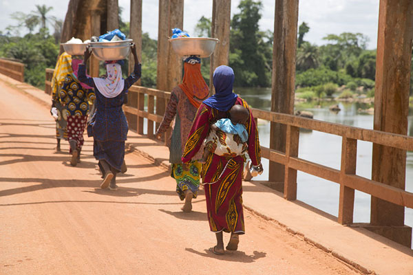 Women walking the bridge with their wares | Pont Weygand | Ivoorkust