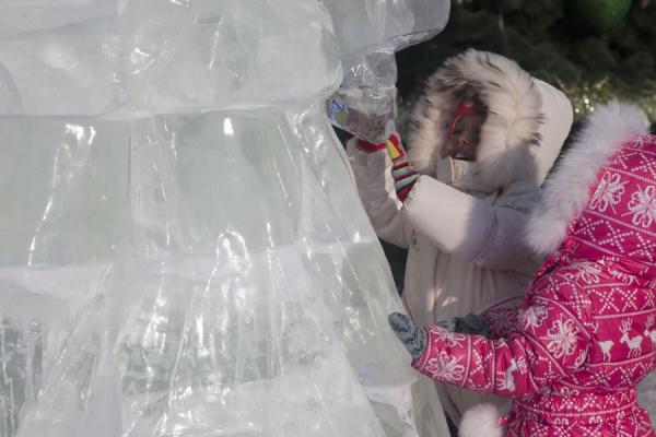 Photo de Two Kazakh girls playing with an ice sculpture in the sculpture park in AstanaAstana - Kazakhstan