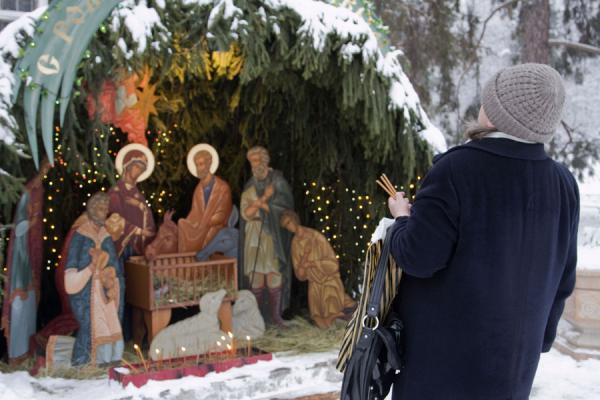 Photo de Woman with candles in front of the Nativity sceneCathÃ©drale de la Sainte Ascension - Kazakhstan