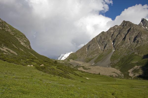 Wider part of Ak-Suu valley, Kyrgyzstan Green slopes and grey mountains in Ak-Suu valley, Kyrgyzstan