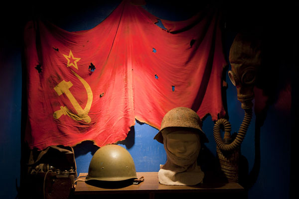 Soviet flag and helmets in the tiny museum of the former military prison of Karosta, Latvia