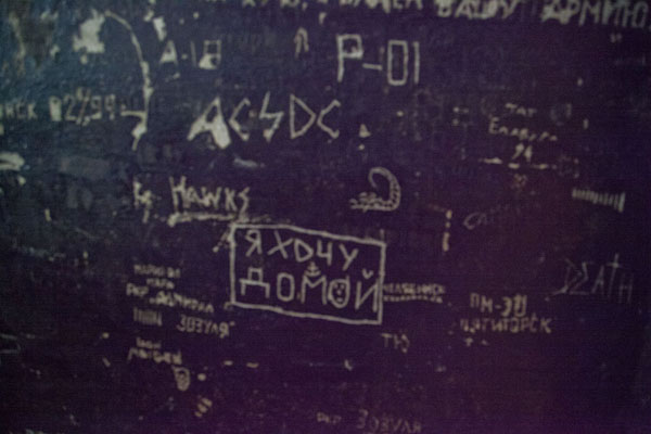 Wall of a cell with various messages, ranging from I want to go home to Roxette and AC/DC, Latvia